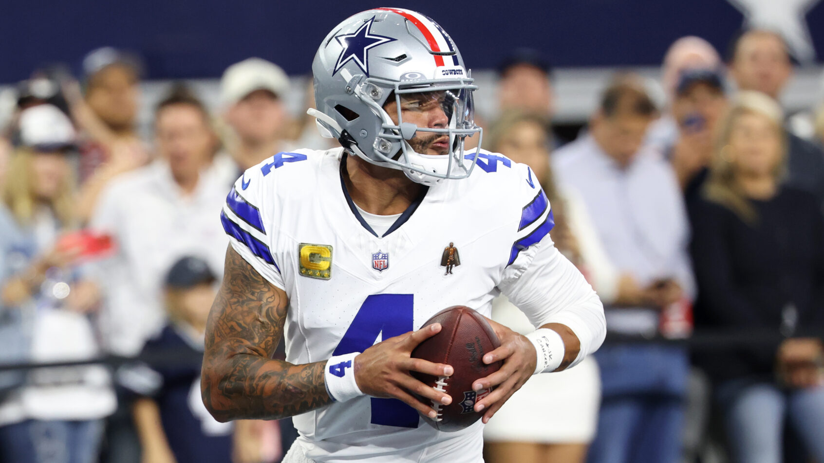 Dallas Cowboys quarterback Dak Prescott rolling out of the pocket