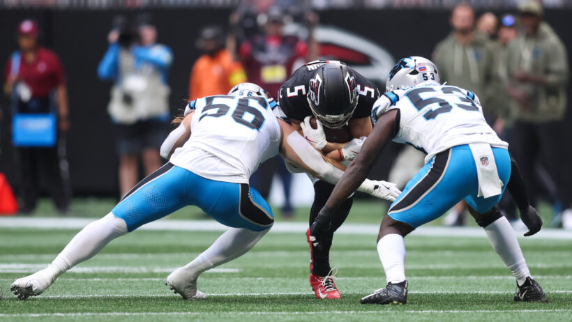 Atlanta Falcons wide receiver Drake London gets tackled by Carolina Panthers linebackers Christian Rozeboom and Claudin Cherelus