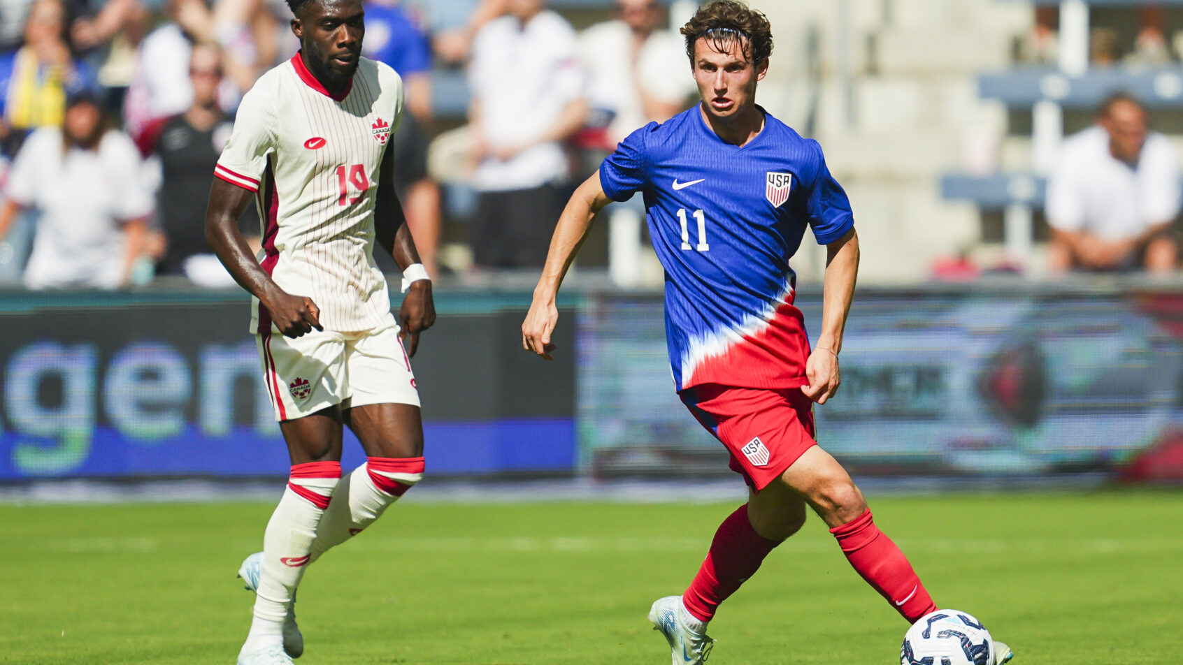 United States forward Brenden Aaronson controls the ball against Canada defender Alphonso Davies