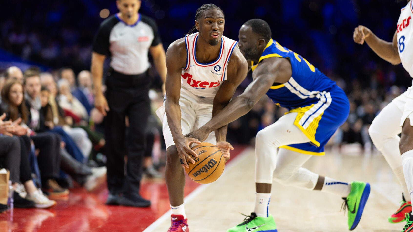 Philadelphia 76ers guard Tyrese Maxey dribbles past Golden State Warriors forward Draymond Green