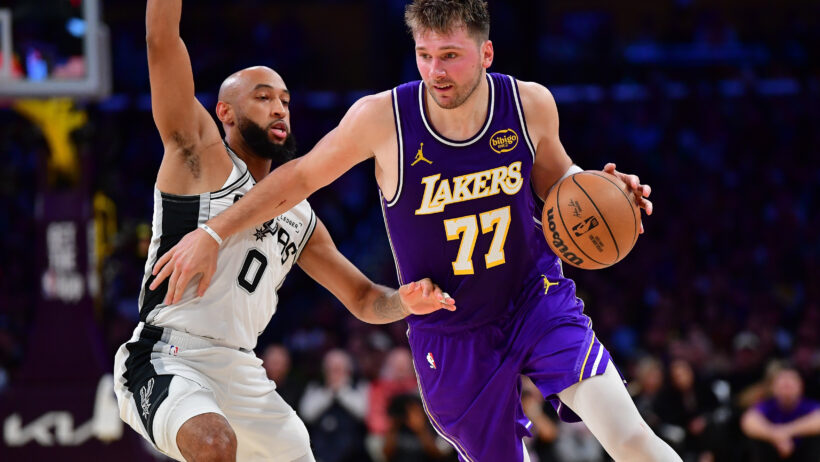 Los Angeles Lakers guard Luka Doncic dribbles around San Antonio Spurs guard Jordan McLaughlin