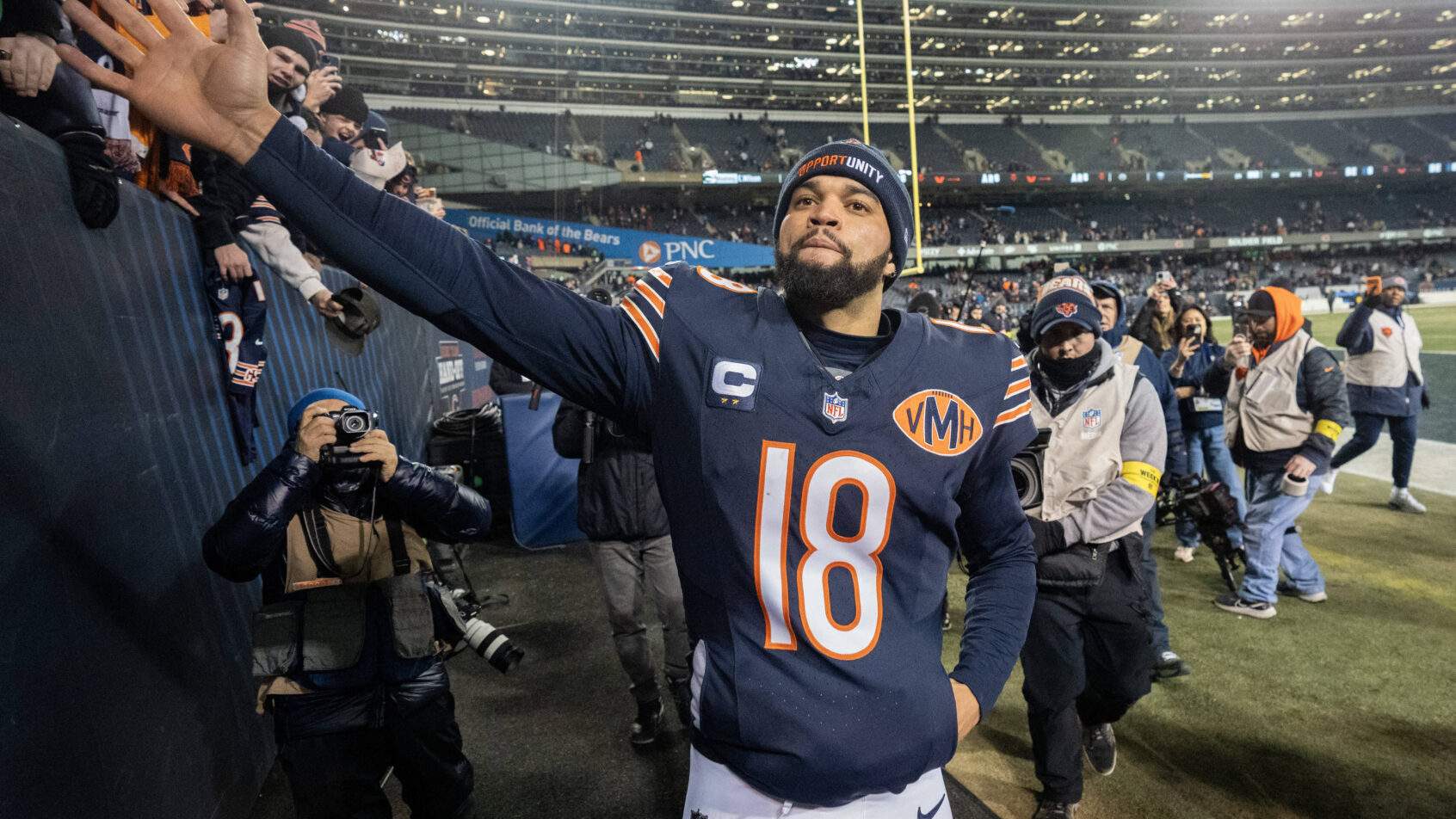 Caleb Williams high fives a fan after the game