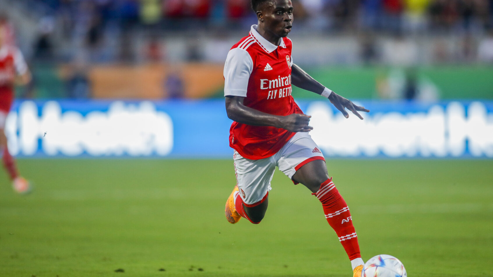 Arsenal midfielder Bukayo Saka running with the ball