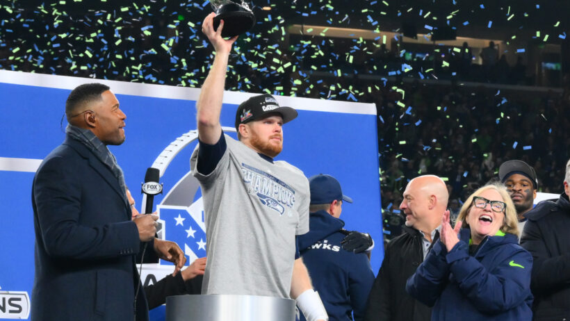 Seattle Seahawks quarterback Sam Darnold lifts the NFC Championship Trophy