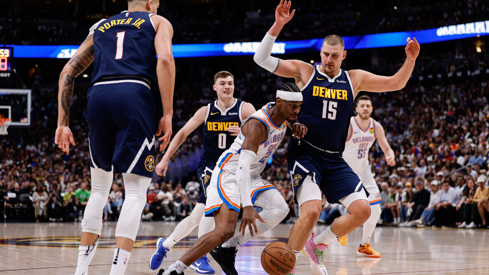 Oklahoma City Thunder guard Shai Gilgeous-Alexander drives to the rim as Denver Nuggets center Nikola Jokic defends