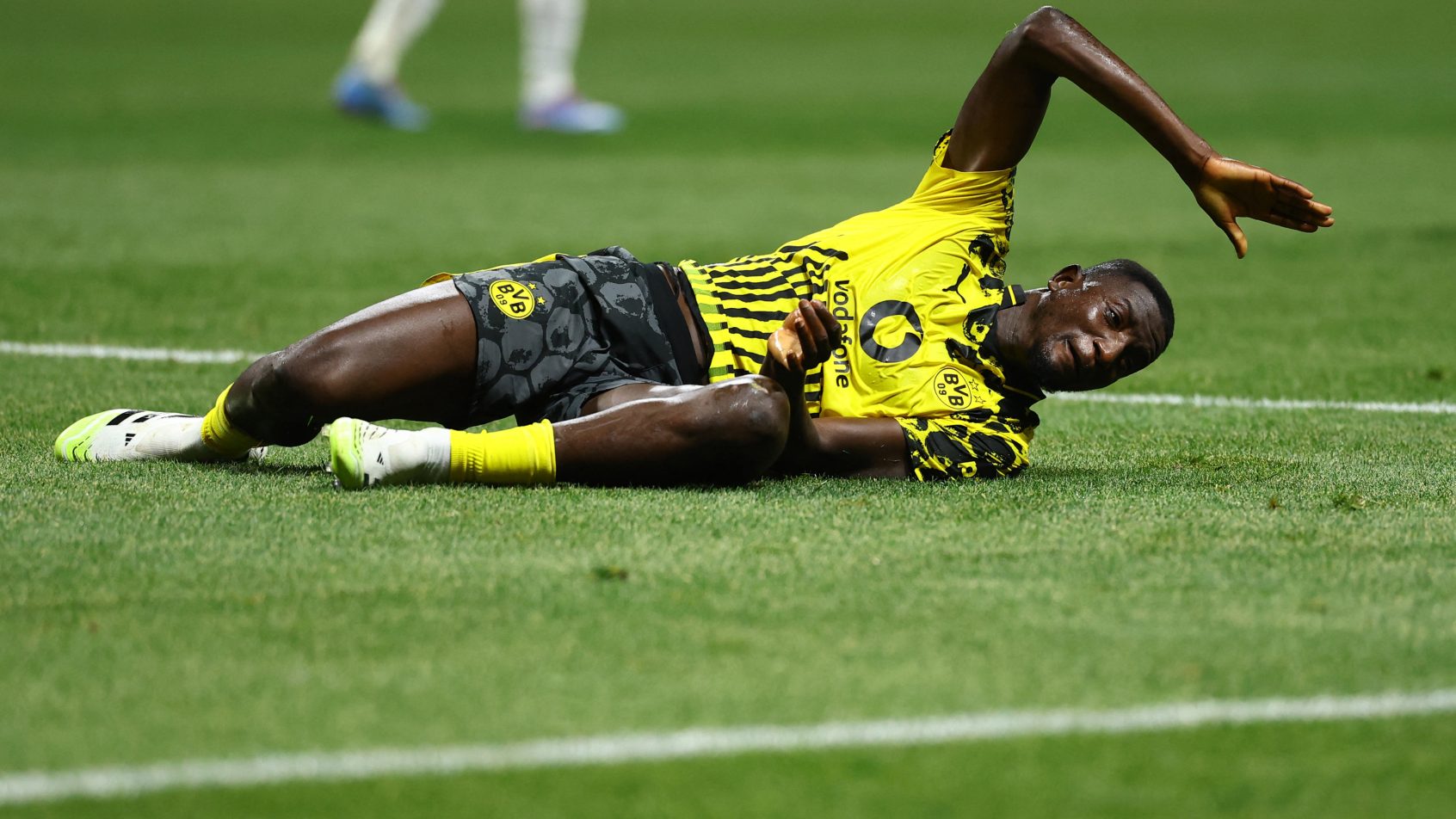 Borussia Dortmund forward Serhou Guirassy laying on the pitch