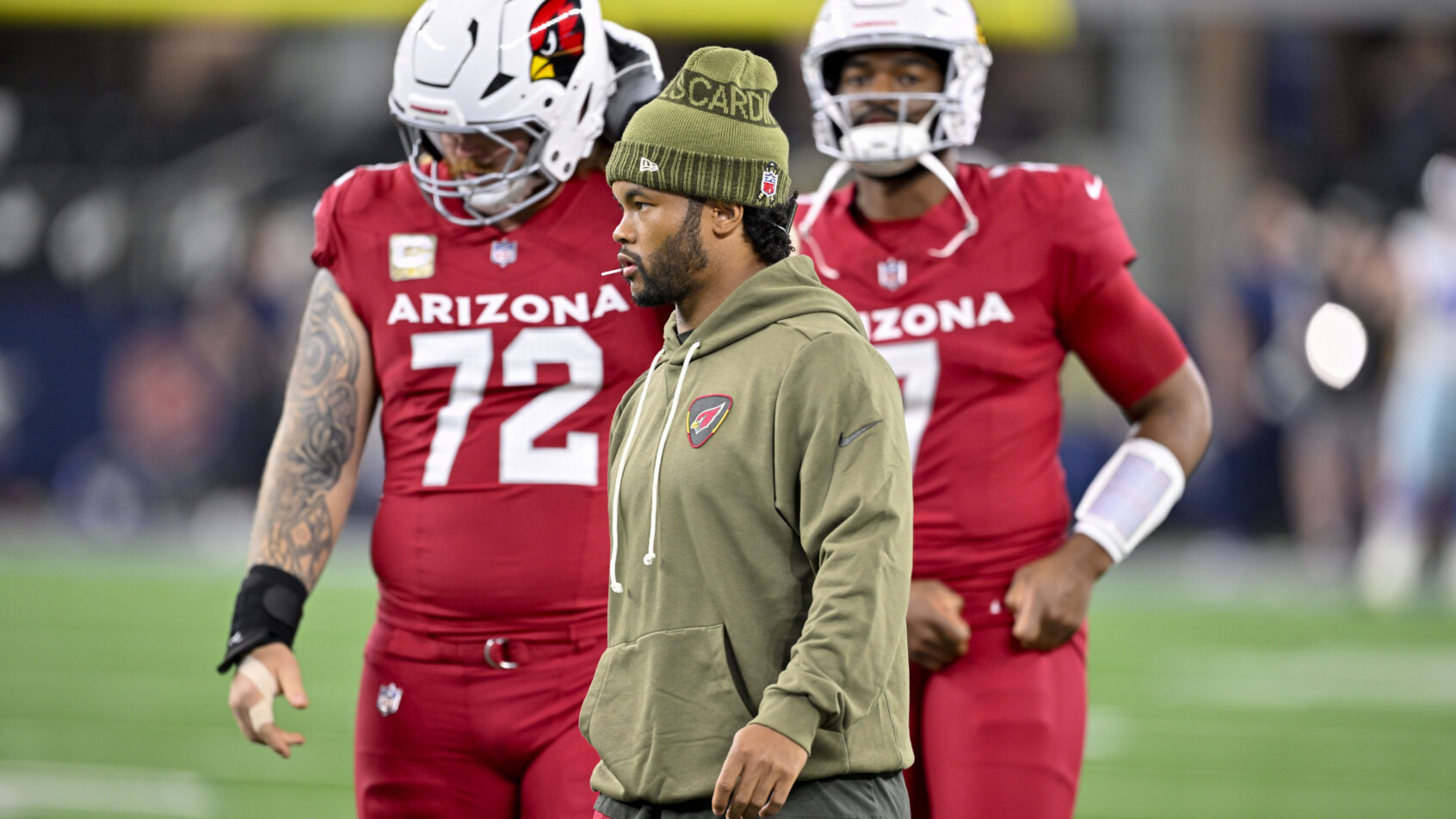 Arizona Cardinals quarterback Kyler Murray on the field in street clothes
