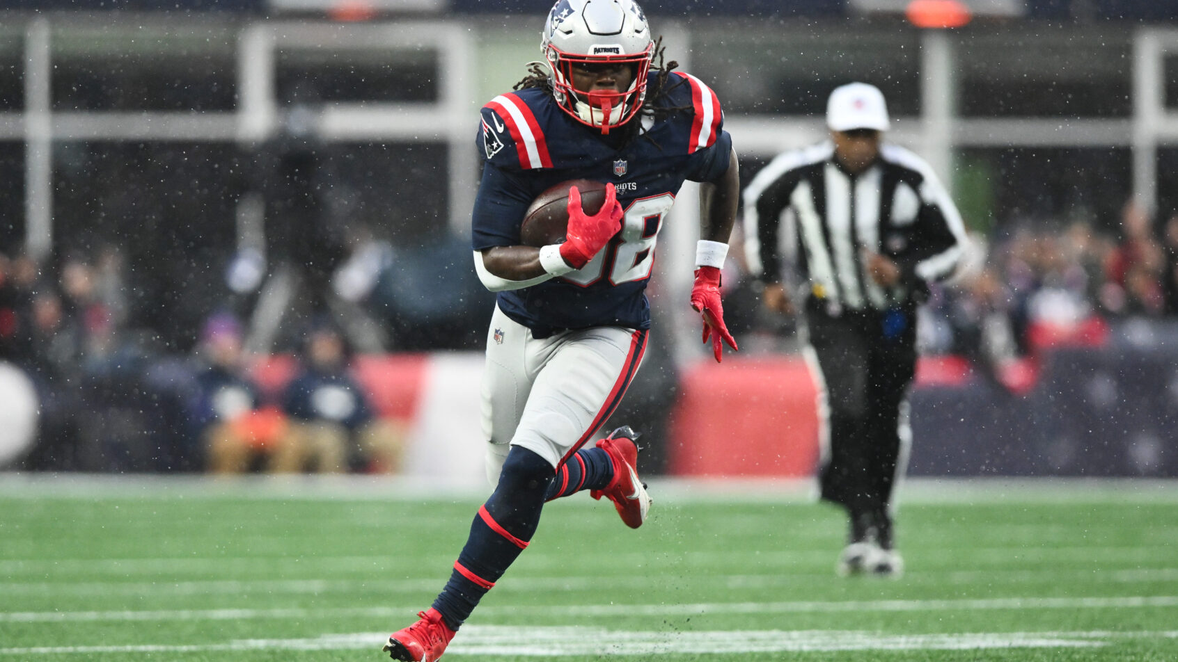 New England Patriots running back Rhamondre Stevenson runs with the ball
