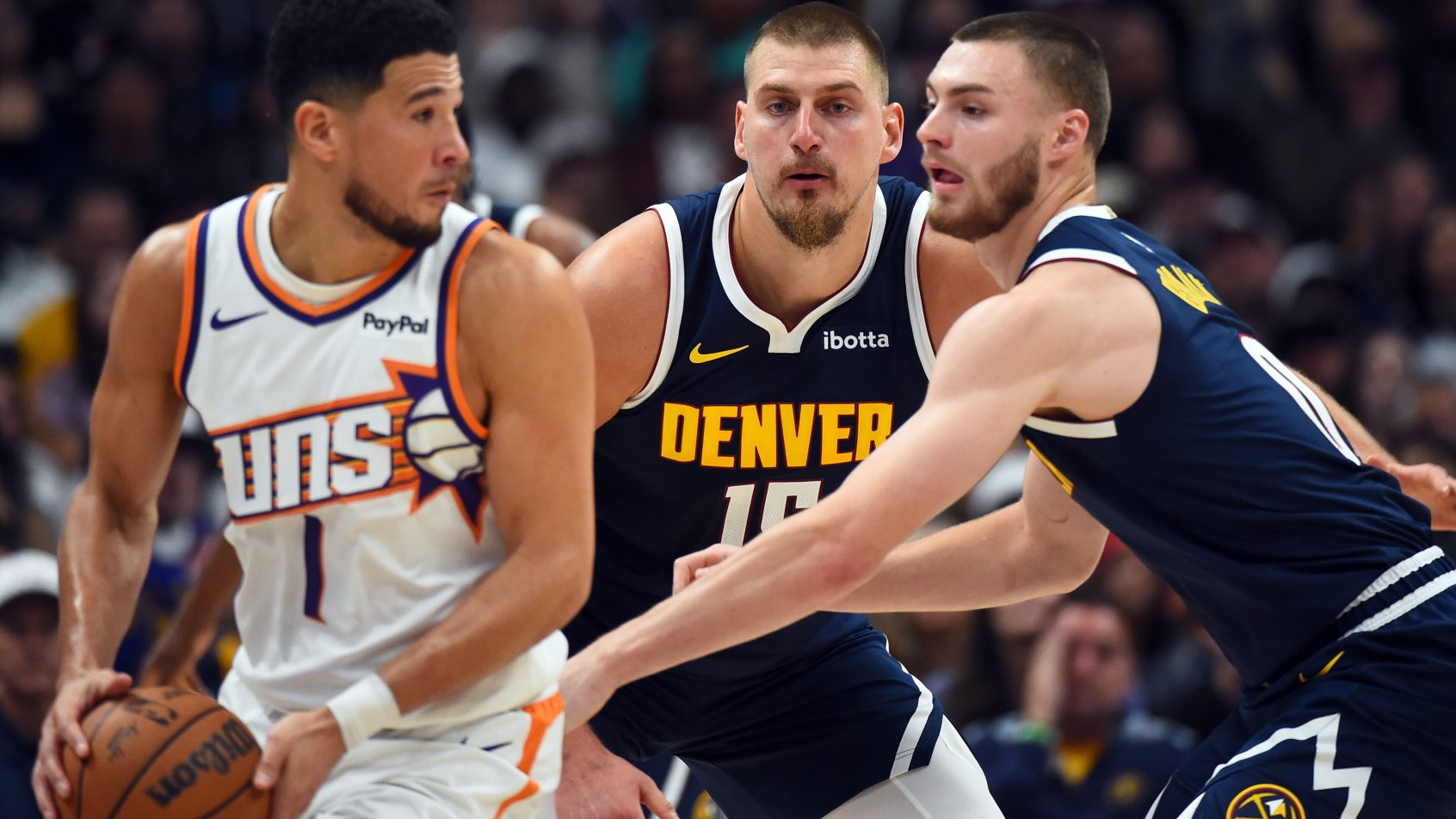 Nikola Jokic and guard Christian Braun defend Devin Booker