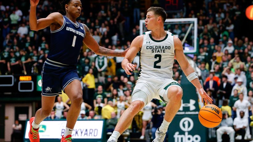 Colorado State Rams guard Brandon Rechsteiner dribbles the ball against a Utah State defender.
