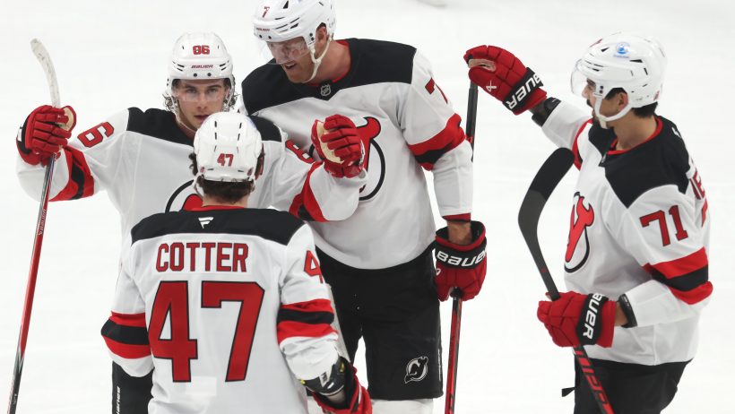 Jack Hughes celebrates with his teammates following a Devils goal.