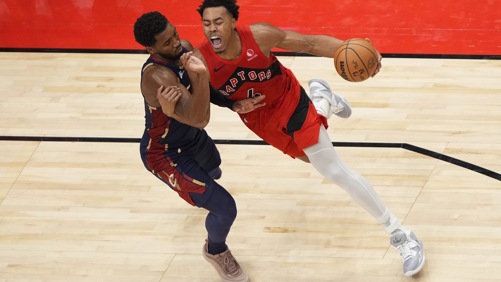 Toronto Raptors guard Scottie Barnes drives at Cleveland Cavaliers guard Donovan Mitchell