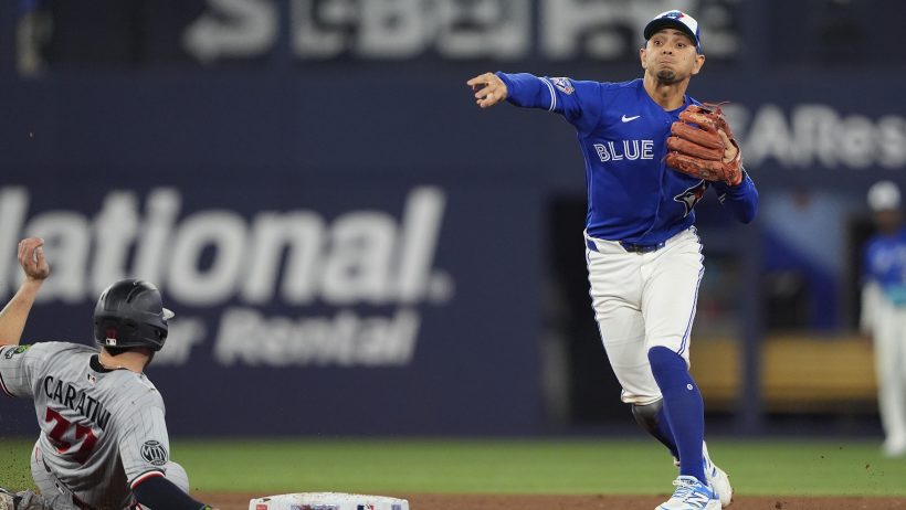 Andres Gimenez tries to turn a double play