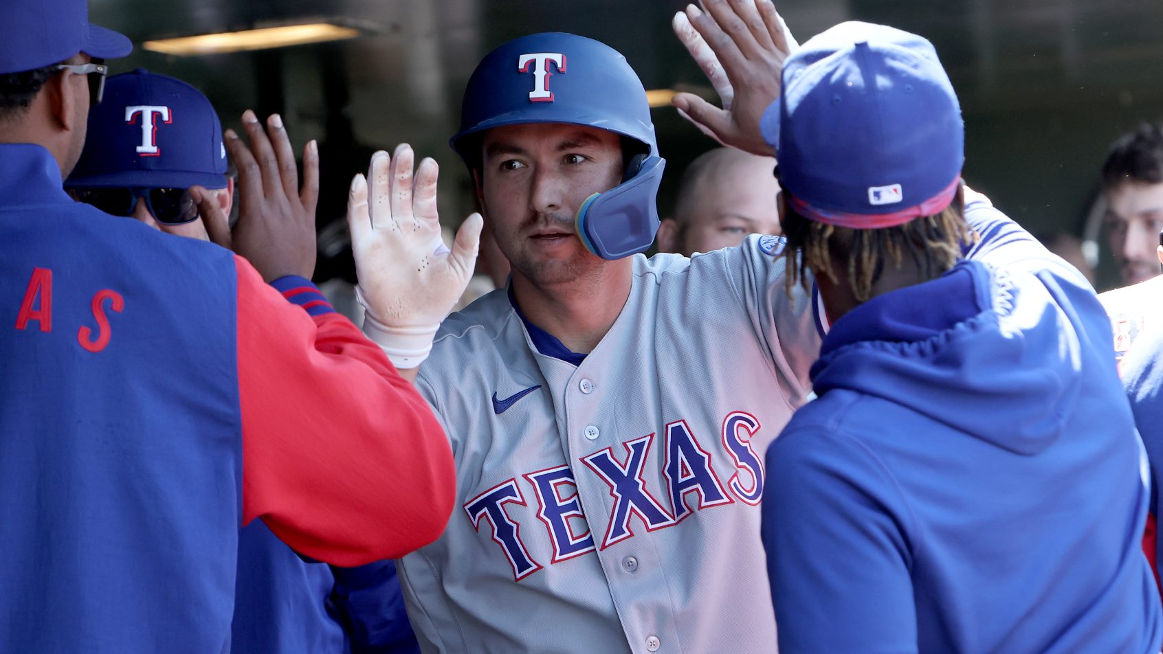 The Rangers dugout celebrates a run versus the A's.