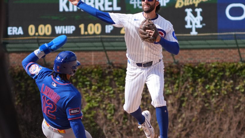 Chicago Cubs shortstop Dansby Swanson throwing turning a double play