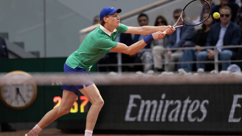 Jannik Sinner stretches to hit a backhand at the French Open