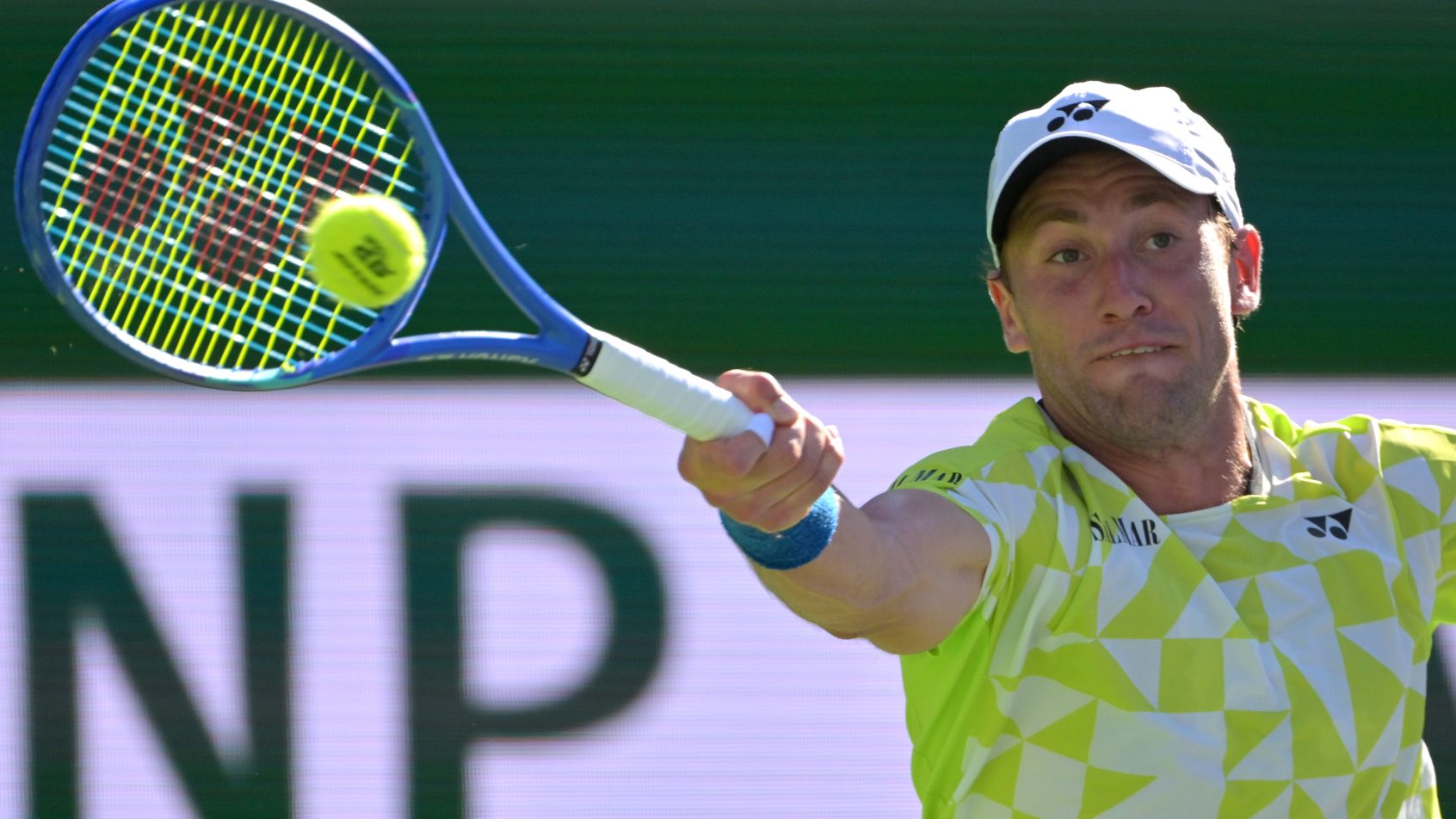 Casper Ruud stretches to hit a forehand