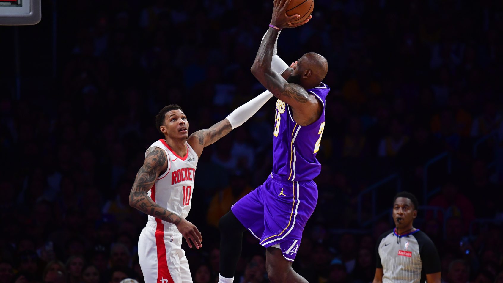 LeBron James rises up for a shot with a hand in his face.