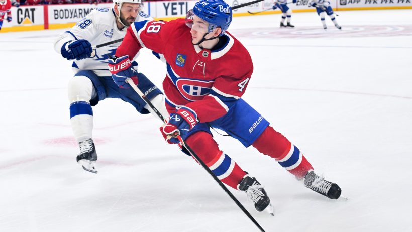 Lane Hutson controls the puck in his own end with a Lightning forechecker right on him.