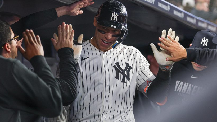 Aaron Judge celebrates with his teammates in the Yankees dugout.