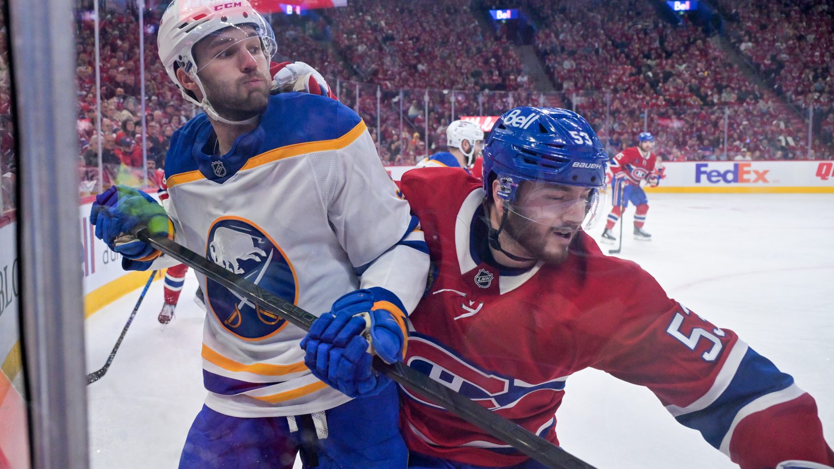 Josh Norris and Noah Dobson battle in the corner of an NHL playoff game.