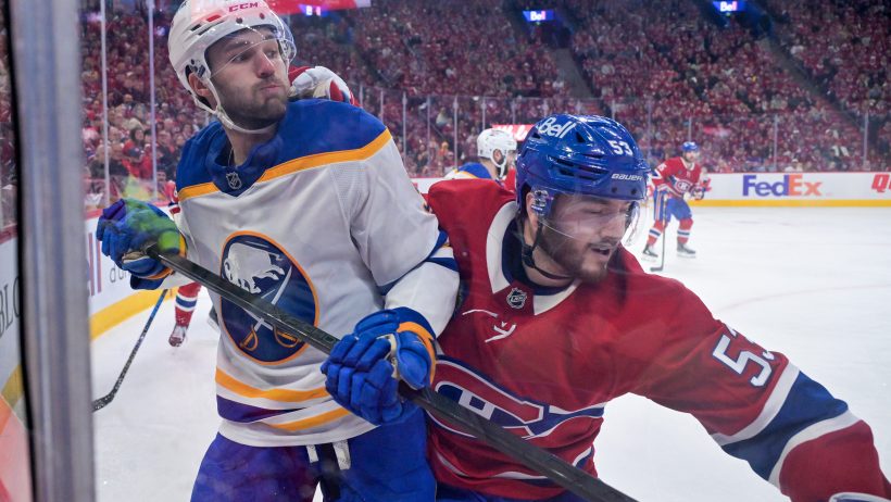 Josh Norris and Noah Dobson battle in the corner of an NHL playoff game.