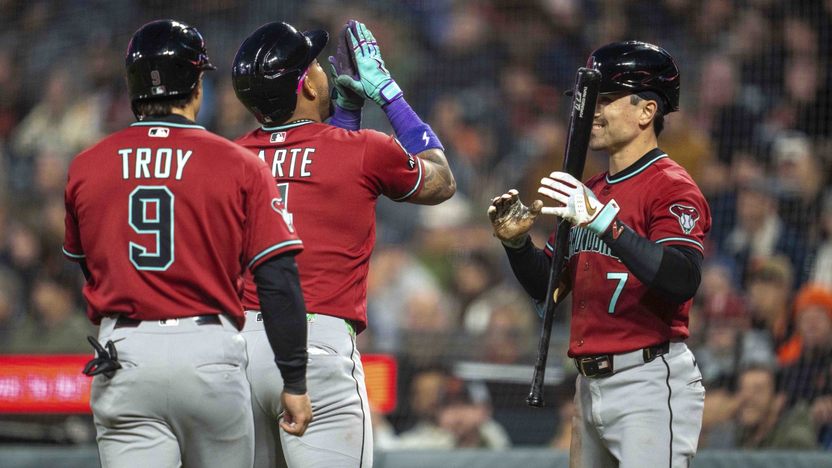 The Arizona Diamondbacks celebrate at home plate versus the San Francisco Giants.