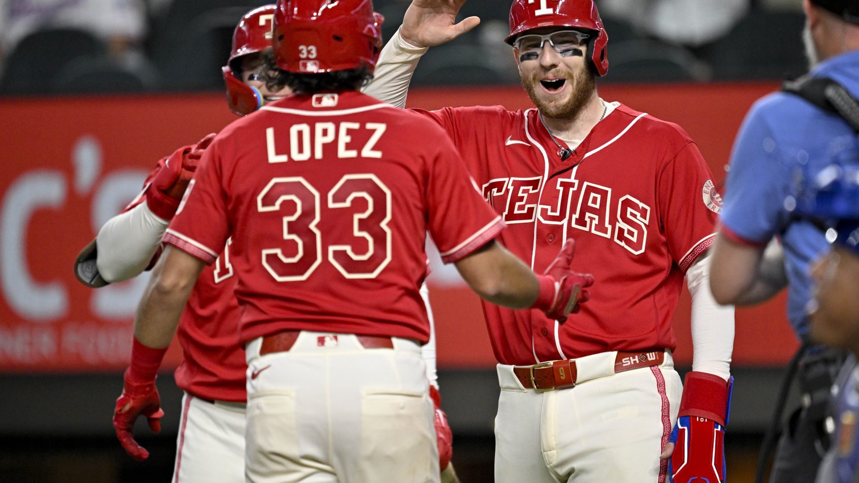 The Rangers celebrate a home run versus the Royals at home plate.
