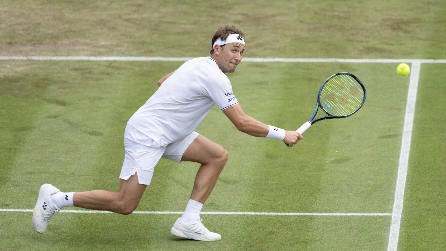 Casper Ruud reaching to hit a backhand volley