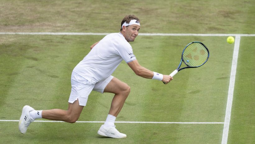 Casper Ruud reaching to hit a backhand volley