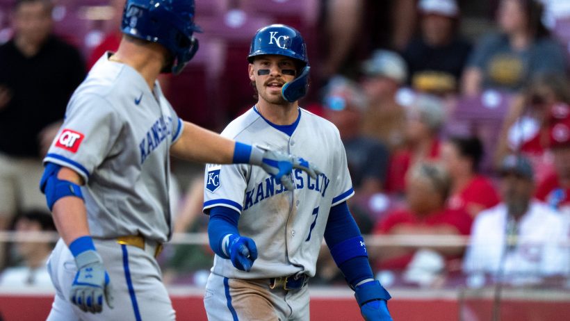 Bobby Witt Jr. gets a high five from his teammate after scoring a run.