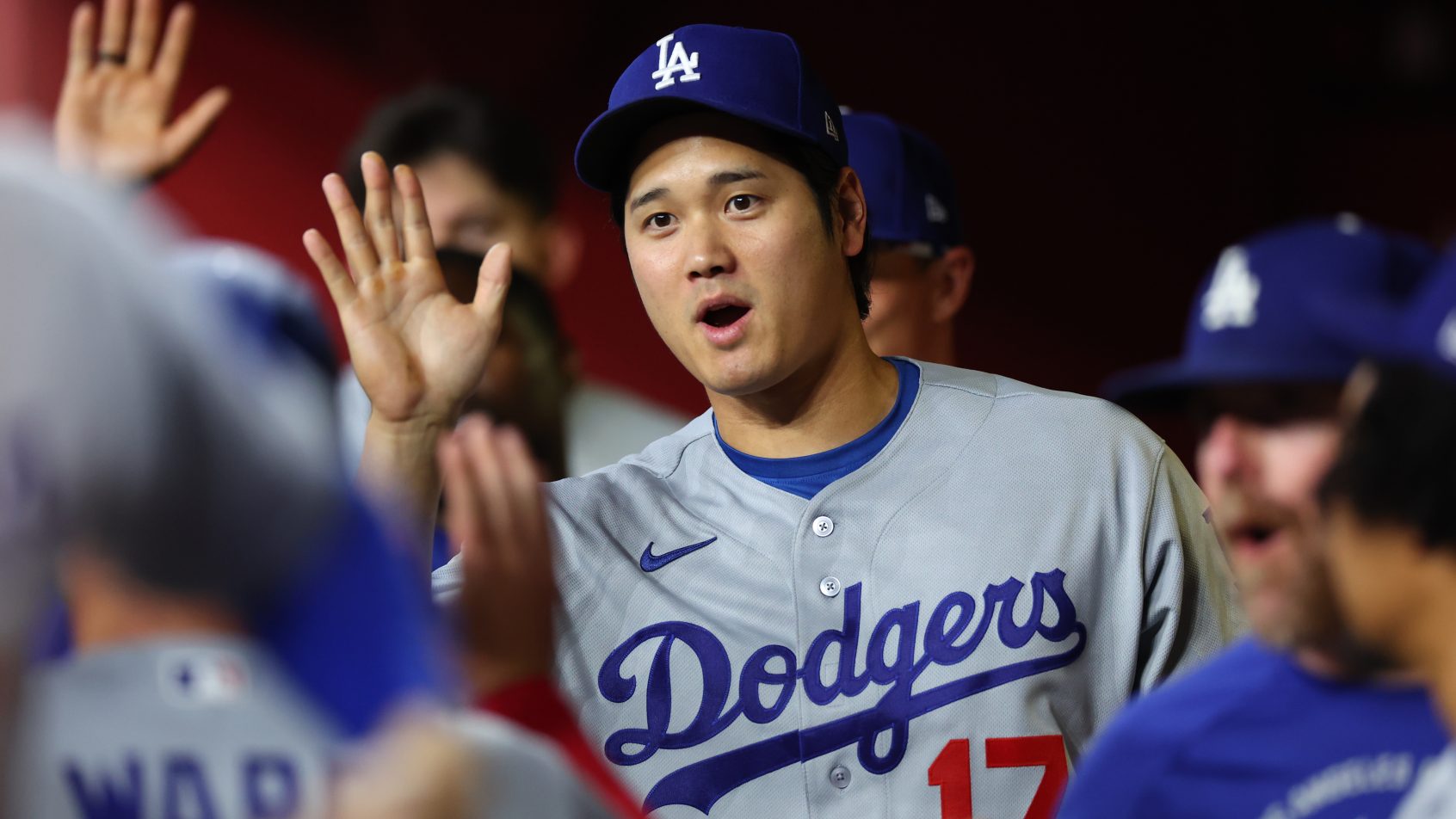 Shohei Ohtani celebrates with his Dodger teammates in the dugout.