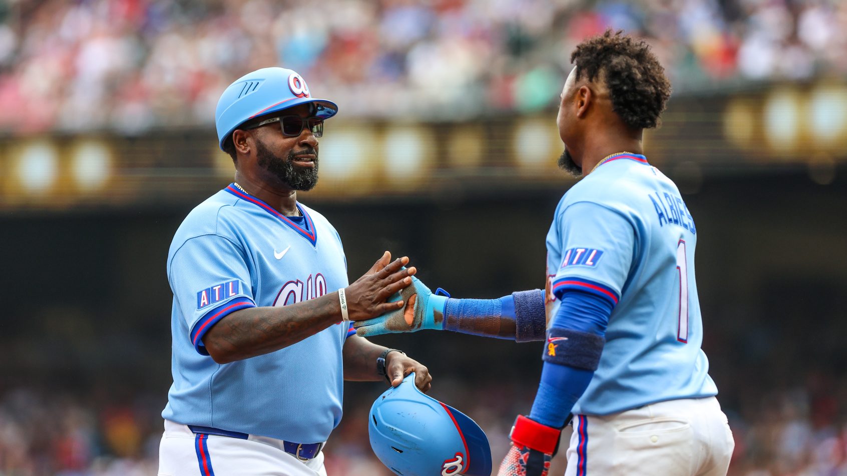 The Braves celebrate after scoring a run versus the Pirates.