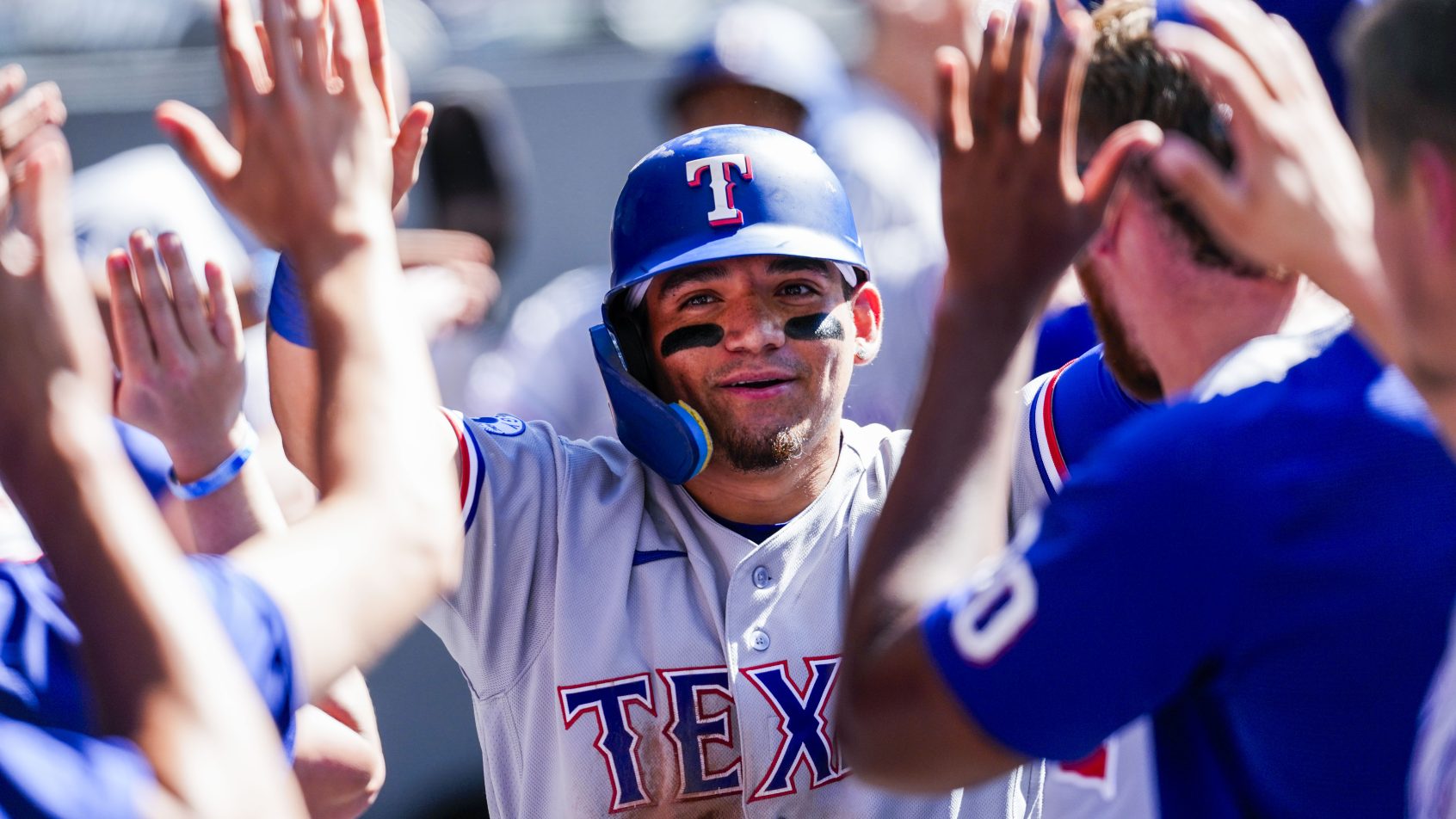 The Rangers celebrate a run in their dugout against the Blue Jays.