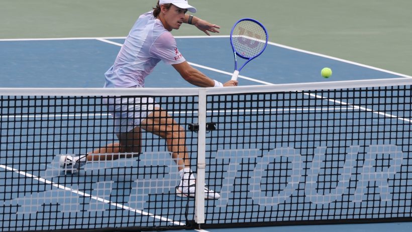 Alex de Minaur hitting a backhand volley