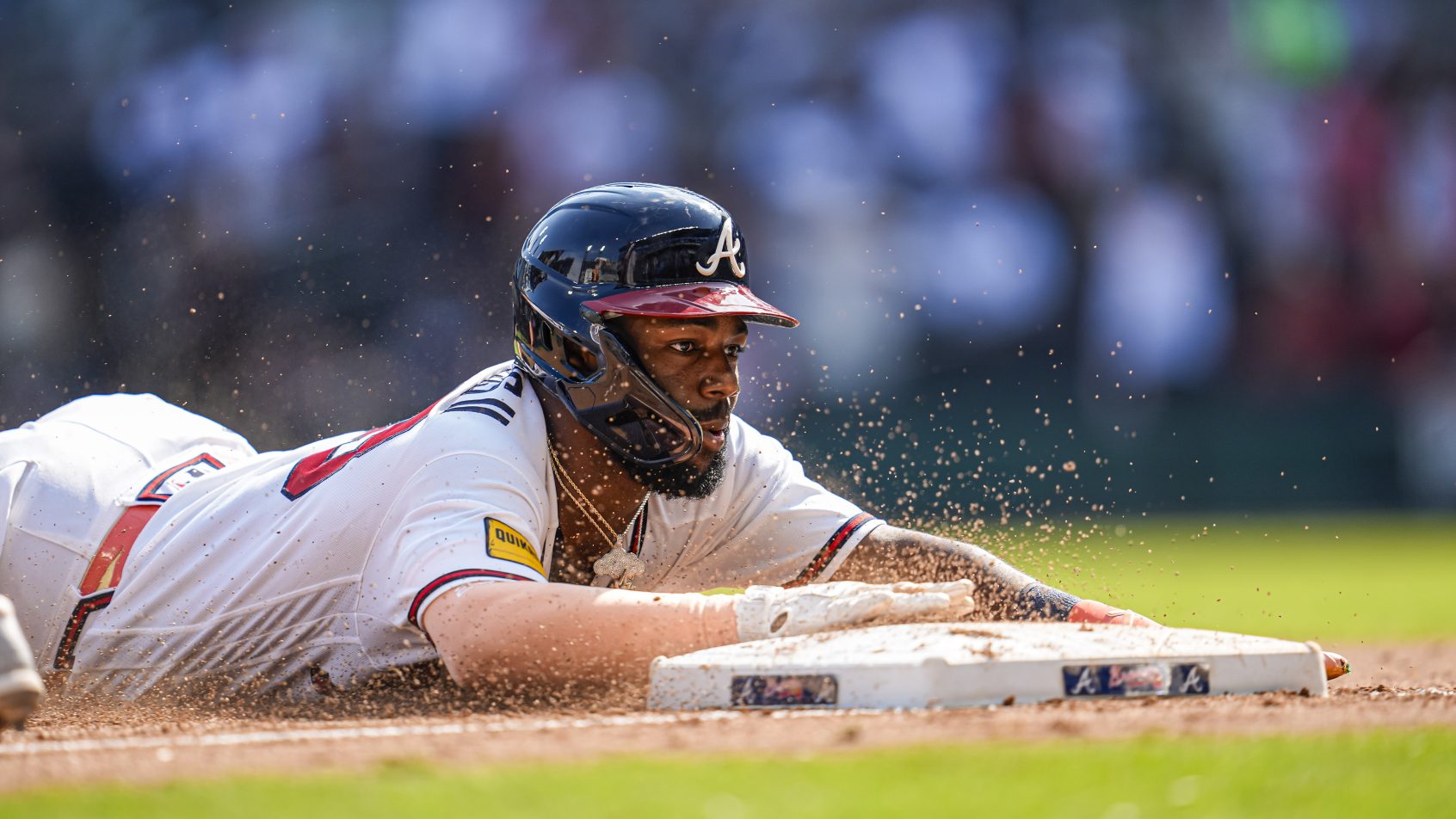 Michael Harris II slides safely into 3rd base during a game against the Mets.
