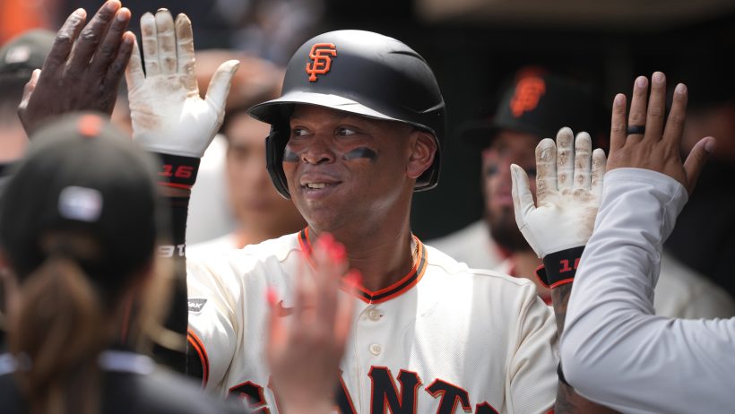 Rafael Devers celebrates a run in the Giants dugout.