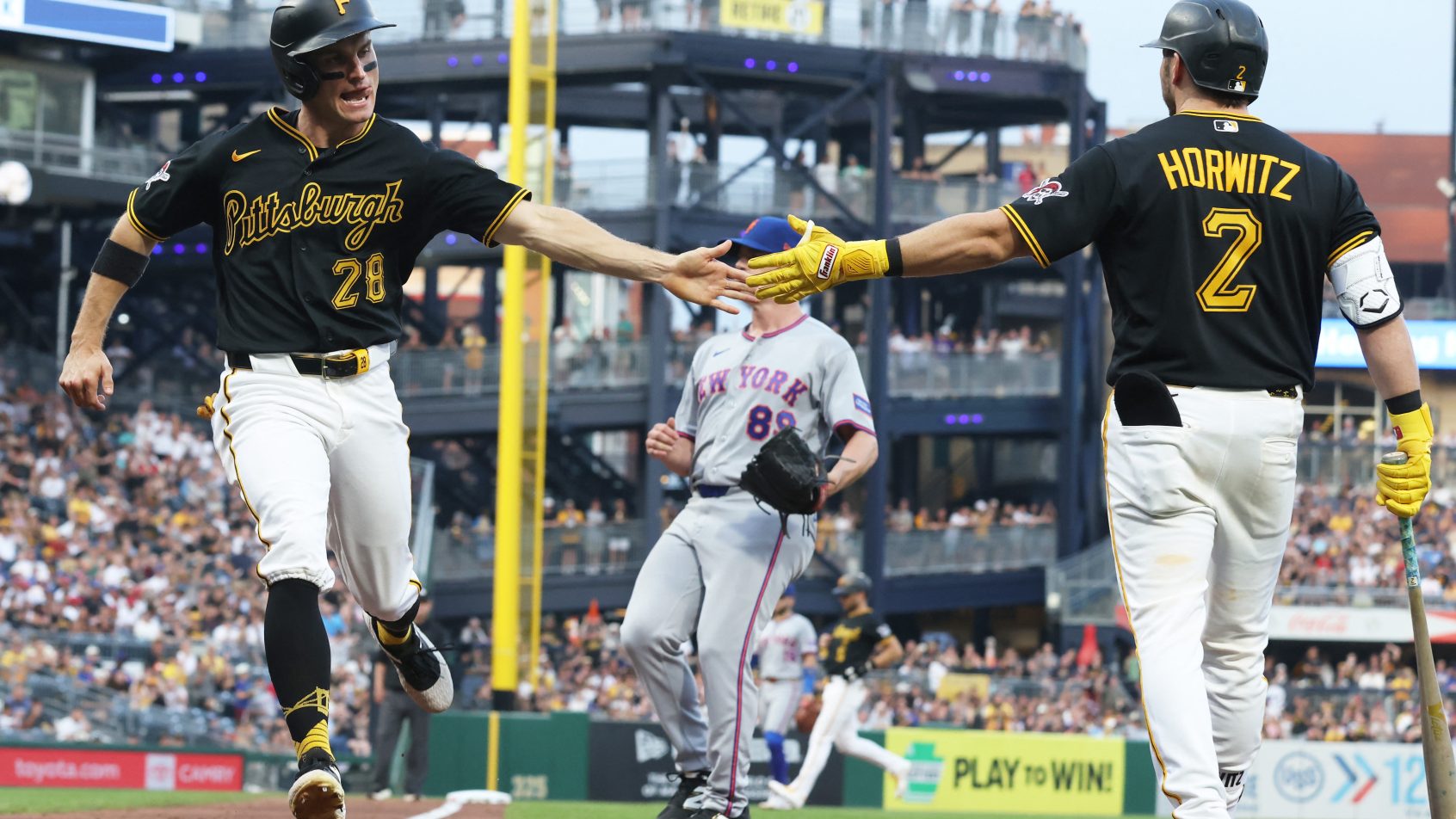 The Pirates celebrate a run versus the Mets.