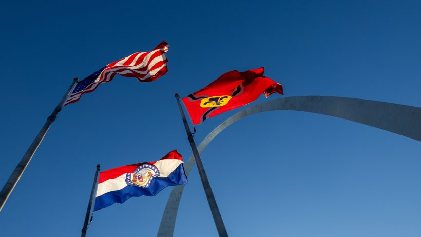 Flags of the United States, Missouri and City of St. Louis wave below the Gateway Arch on March 28, 2026.