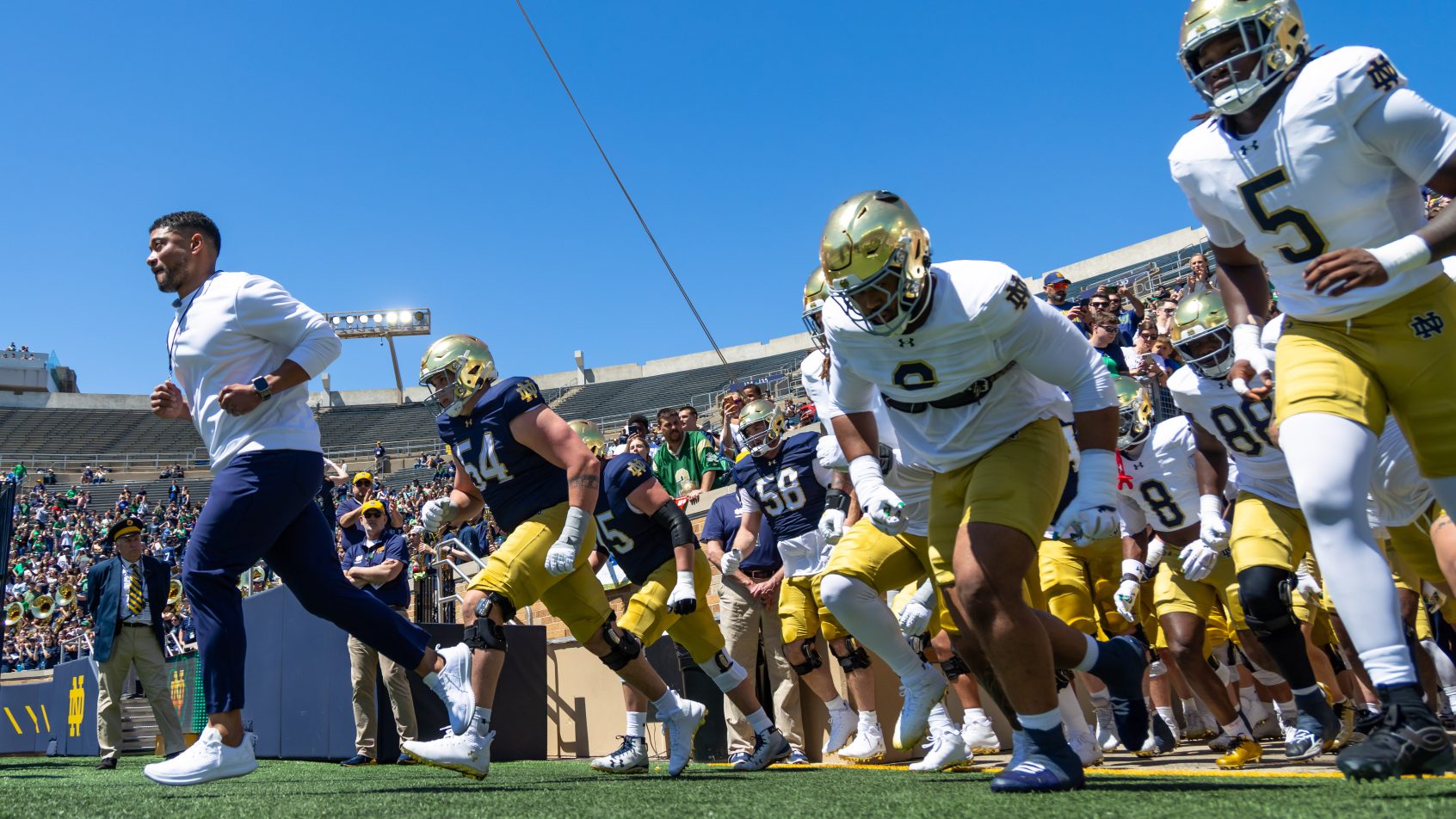 Marcus Freeman leads Notre Dame onto the field for a spring game.