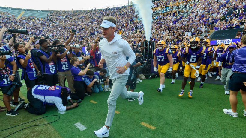 Lane Kiffin leads LSU onto the field.
