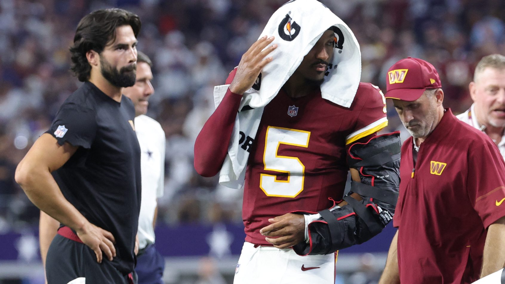 Washington Commanders quarterback Jayden Daniels leaving the field injured