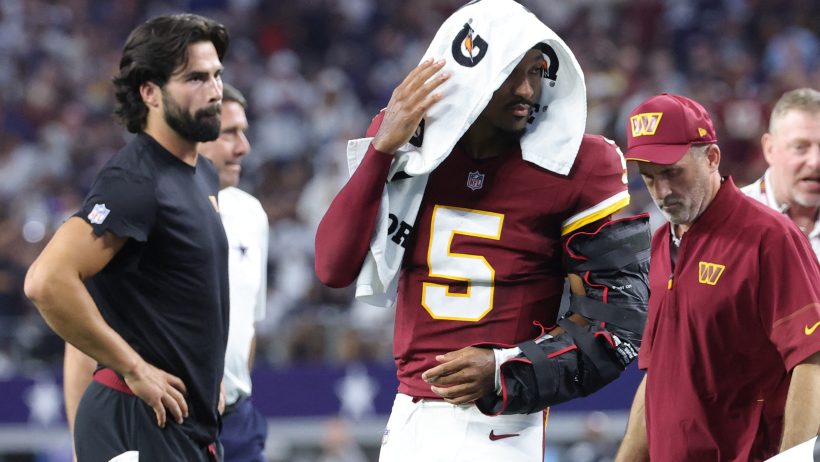 Washington Commanders quarterback Jayden Daniels leaving the field injured