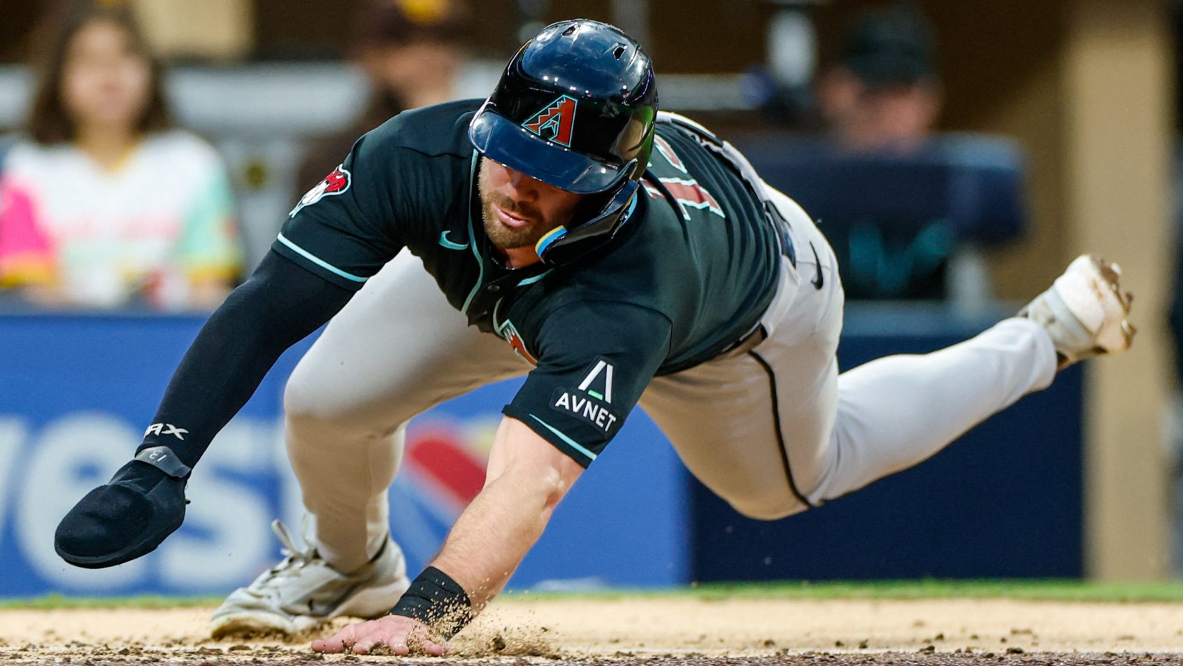 Tim Tawa dives into home to score a run vs the Padres.