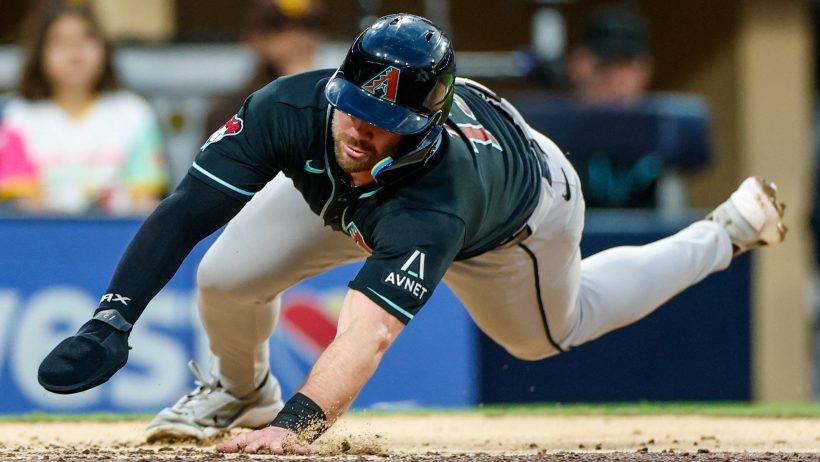 Tim Tawa dives into home to score a run vs the Padres.
