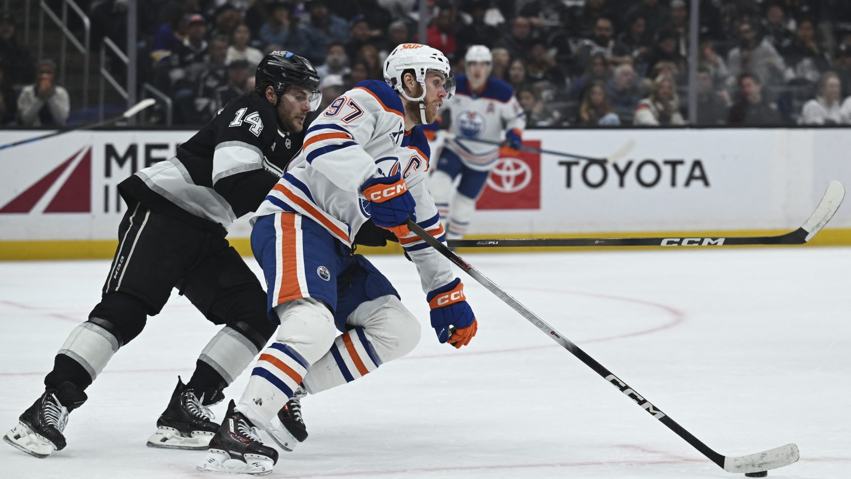 Connor McDavid tries to keep the puck away from an LA Kings forward.