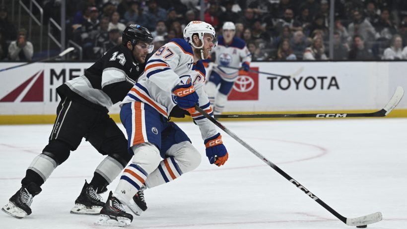 Connor McDavid tries to keep the puck away from an LA Kings forward.