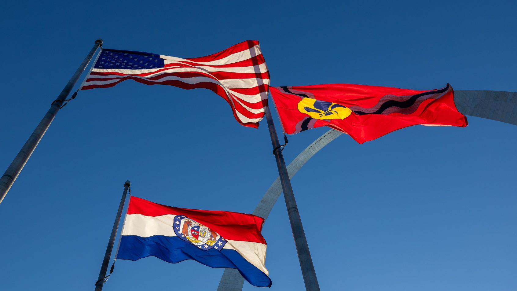 Flags of the United States, Missouri and City of St. Louis fly in front of the Gateway Arch on March 28, 2026.