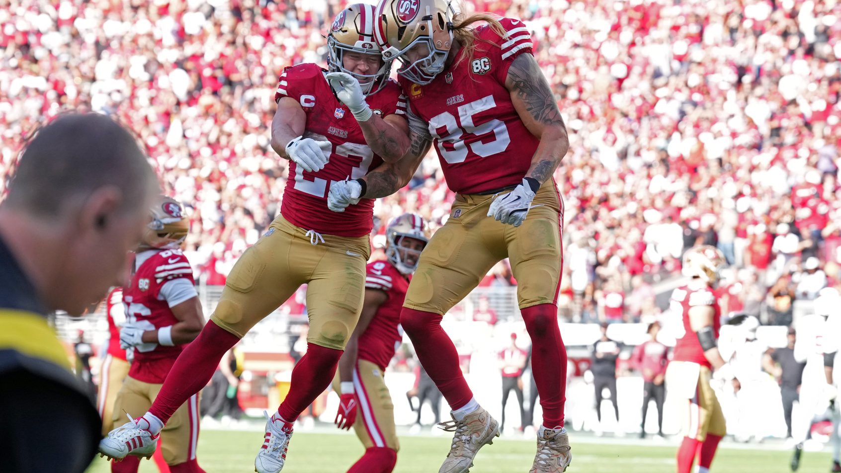 George Kittle celebrates with running back Christian McCaffrey.