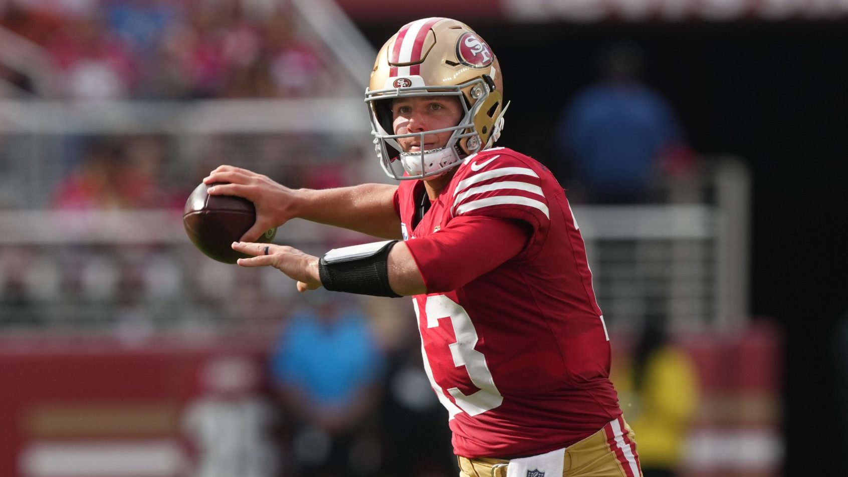 Brock Purdy throws on the run vs the Broncos.